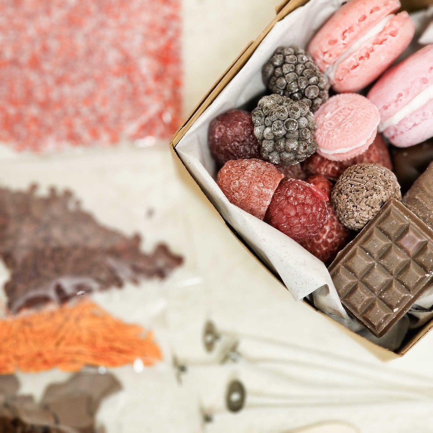 Detailaufnahme der Kerzen-Toppings im Starterset: Himbeeren, Brombeeren, Macarons, Cookies und Schokoladenstücke für realistische Dessertkerzen.