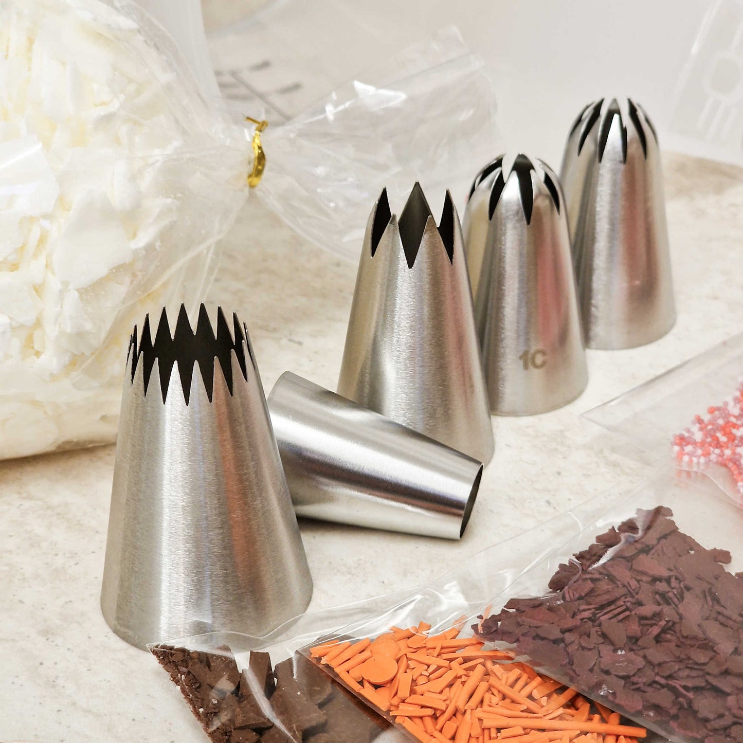 Nahaufnahme der Spritztüllen, die im Kerzen-Starterset für Dessertkerzen enthalten sind, zeigt unterschiedliche Formen und Größen.