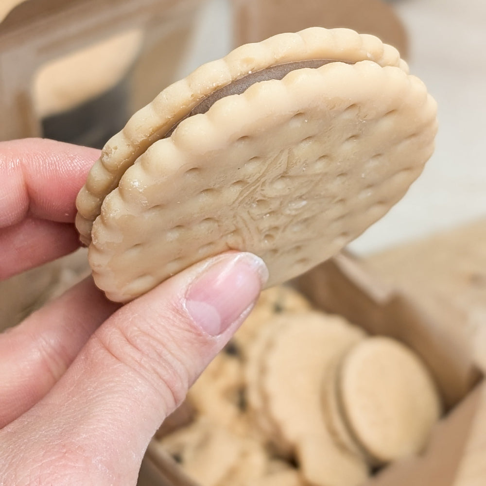 Detailaufnahme eines Keks-Wachs-Toppings in der Hand, um die Größe zu zeigen.